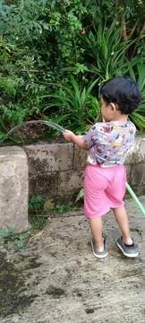 Three Year Old Boy Watering Garden Hose Candid Back View Stock Photos