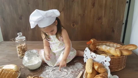 A three-year-old girl  draws with her hands on flour Stock Footage 157126418