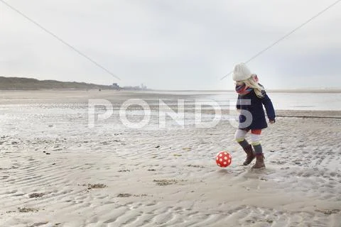 Three Year Old Girl Playing Football On Beach, Bloemendaal Aan Zee, Netherlands