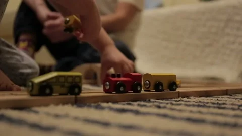 Three years old boy plays with wooden railroad in room. Just hands. Close up Stock Footage 86418268