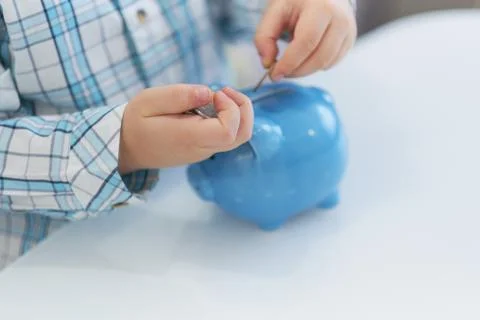 Three years old boy puts money in a piggy bank, piggybank concept. mantesori  Stock-Fotos