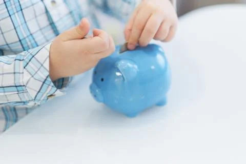 Three years old boy puts money in a piggy bank, piggybank concept. mantesori  Foto stock