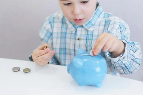 Three years old boy puts money in a piggy bank, piggybank concept. mantesori  Foto stock