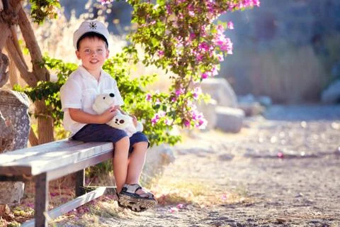 Three years old boy sitting on bench Stock Photos