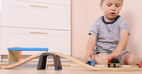 Three years old child boy play with wooden train, build toy railroad at home Stock Footage 96213746
