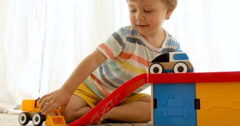 Three years old child boy play with wooden toy cars Stock Footage 112860894