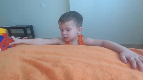 Three years old child boy play with train, build toy railroad at home. Видео 124456193