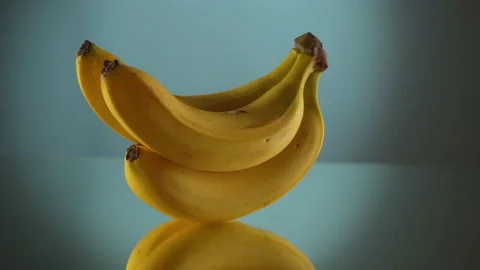Three yellow bananas on turntable Stock Footage 171547423
