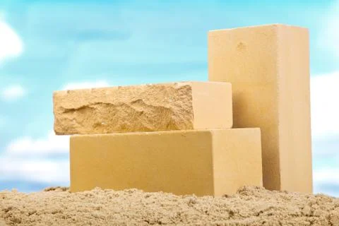 Three yellow ceramic bricks on the sand at the blue sky background Stock Photos