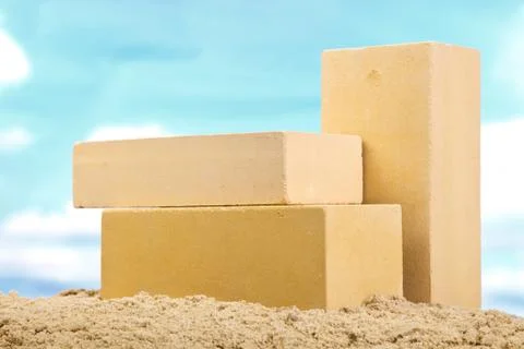 Three yellow ceramic bricks on the sand at the blue sky background Stock Photos