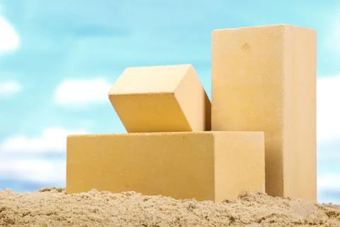 Three yellow ceramic bricks on the sand at the blue sky background Stock Photos