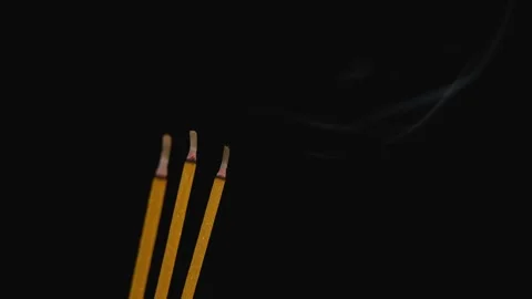 Three yellow incense sticks burning on black Stock Footage 277180145