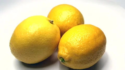 Three yellow lemons on the white background, rotating video Stock Footage 235535657