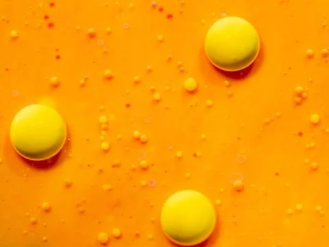 Three yellow spheres on orange background. Close up macro shot. Blurred Foto stock