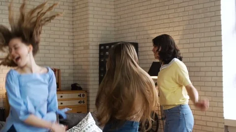 Three young active girlfriends dance disco and hop together, while having fun at Stock Footage 75667868