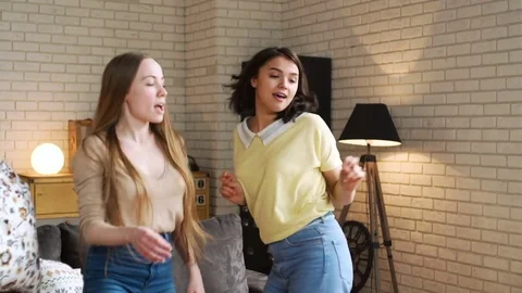 Three young active girlfriends dance disco and hop together, while having fun at Stock Footage 75668236