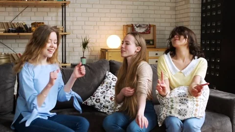 Three young active girlfriends dance disco and hop together, while having fun at Stock Footage 75668272