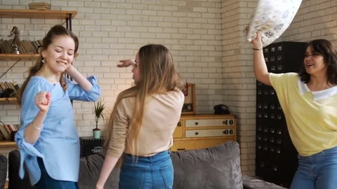 Three young active girlfriends dance disco and hop together, while having fun at Stock Footage 75669069