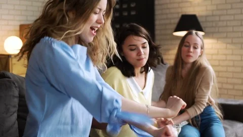 Three young active girlfriends dance disco and hop together, while having fun at Stock Footage 75774907