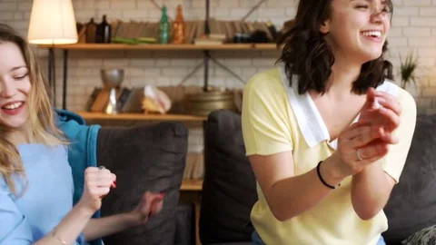 Three young active girlfriends dance disco and hop together, while having fun at Stock Footage 75775000