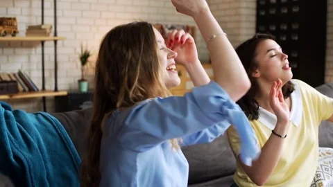 Three young active girlfriends dance disco and hop together, while having fun at Stock Footage 75777987