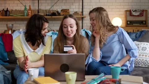 Three young active women make online payment for order by card while shopping Stock Footage 75963338