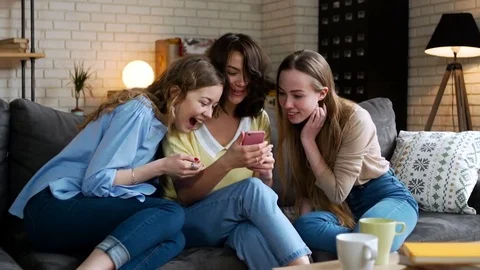 Three young and energetic best friend girls look over photos in telephone mobile Stock Footage 74994389