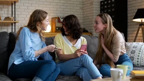 Three young and energetic best friend girls look over photos in telephone mobile Stock Footage 74995122