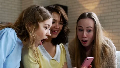 Three young and energetic best friend girls look over photos in telephone mobile Stock Footage 74995228