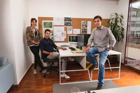 Three young architects discussing about business issues after the meeting ins Stock Photos