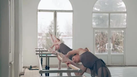 Three young ballerinas train to dance ballet in ballet classroom near ballet Stock Footage 150224810