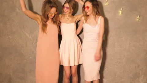 Three young beautiful smiling hipster girls in summer casual pink dresses Stock Footage 140802065