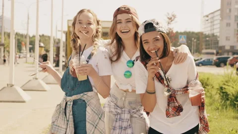 Three young beautiful smiling hipster girls in trendy summer clothes Stock Footage 146052889