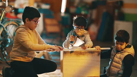Three young brothers working together in a carpentry workshop Stock Footage 330552397