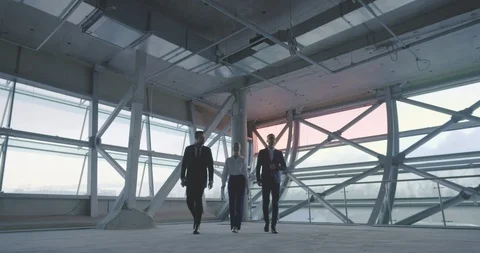 Three young business partners in empty loft of future office Stock Footage 127155493