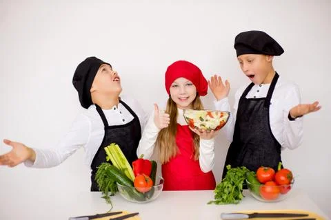 Three young chefs evaluate a salad isolated Stock Photos