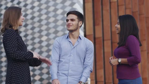 Three young colleagues discussing ideas outdoors Stock Footage 133107964