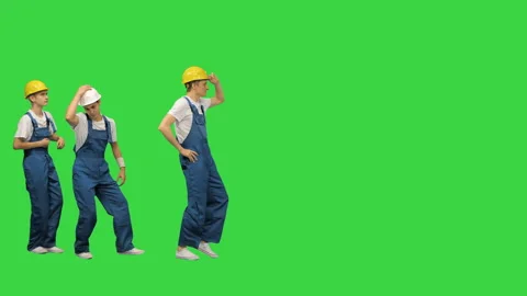 Three young construction workers doing a funny row dance touching their hardhats Stockbeeldmateriaal 139090935