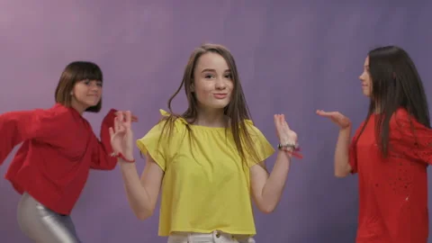 Three young cute smiling hipster girls in summer casual clothes red and yellow Stock Footage 129367004