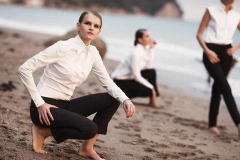 Three young dules on a sandy beach, against the sea. Stock Photos