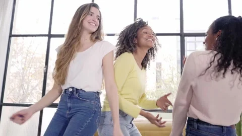 Three young friends dancing singing at home. Cheerful multiracial girls enjoy Stock Footage 244606793
