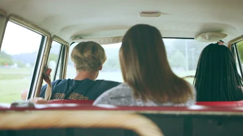 Three young friends get out of broken vintage white station wagon stopped at sid Video stock 199463205