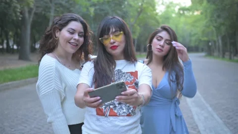 Three young friends taking a selfie and smiling in the city, Stock Footage 154424402