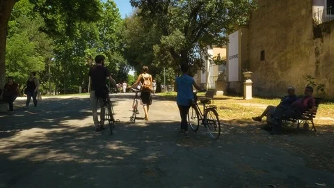 Three young Friends Walking with Bycicles in villa borghese park in Rome on 스톡 동영상 84134718