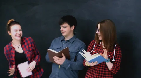Three young guys  with books fun and easy communicate of the board background Stock Footage 63364822