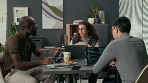 Three Young IT Specialists Discussing Development of New Software Product Stock Footage 329614302