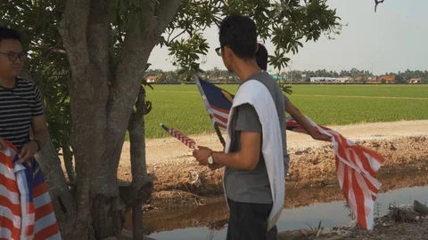 Three young man with Malaysian's flag or Jalur Gemilang. Independent Day Stock Footage 94011264