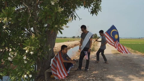 Three young man with Malaysian's flag or Jalur Gemilang. Independent Day Stock Footage 94011522