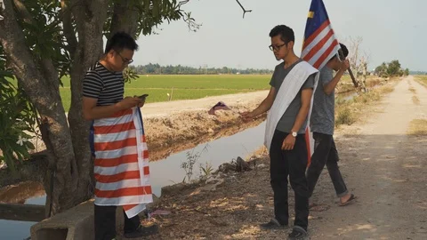 Three young man with Malaysian's flag or Jalur Gemilang. Independent Day Stock Footage 94011762