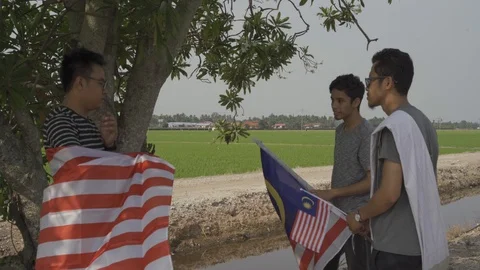 Three young man with Malaysian's flag or Jalur Gemilang. Independent Day Stock Footage 94012146